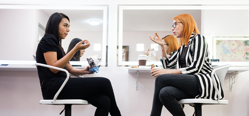 two women talking in salon chairs