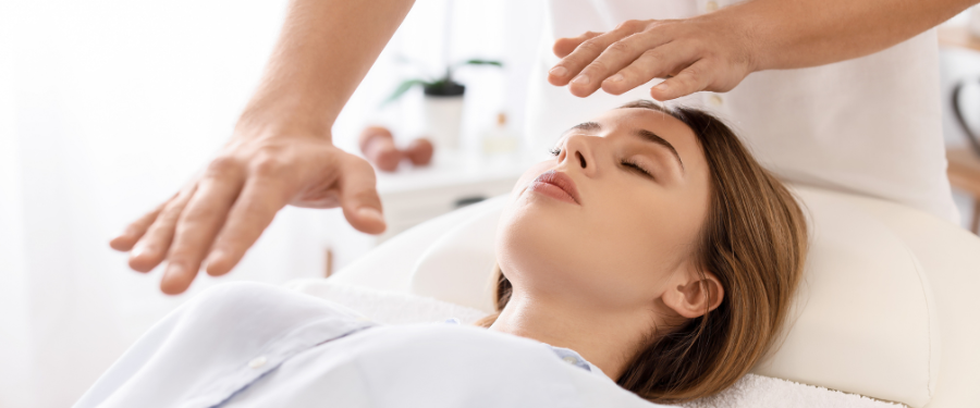 a woman receiving Reiki at a spa - spa trends