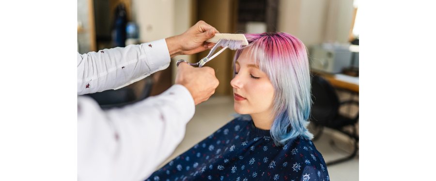 a woman getting a bang trim at a salon
