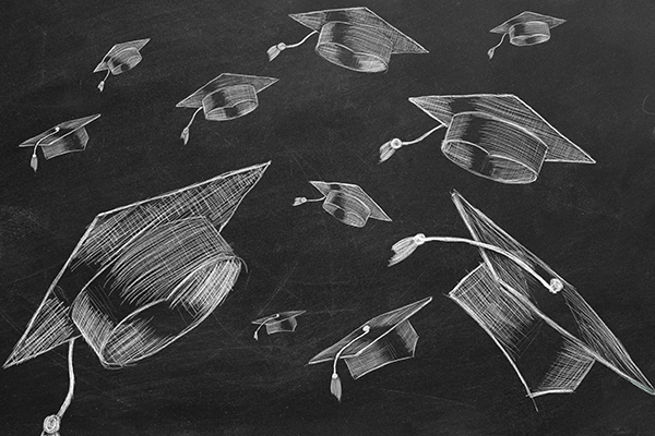 graduation caps drawn on a chalkboard