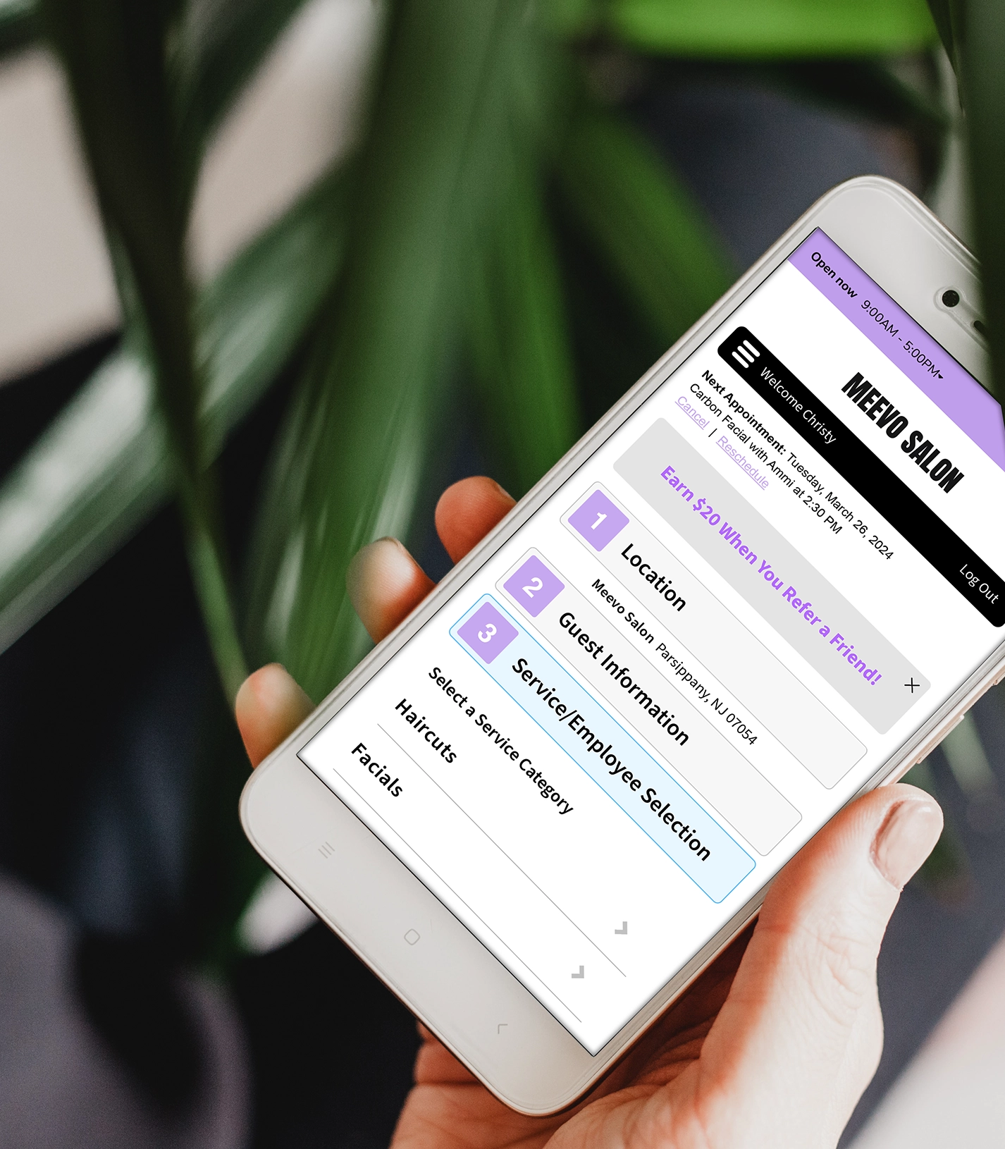 hand holding iphone to make an online appointment on Meevo
