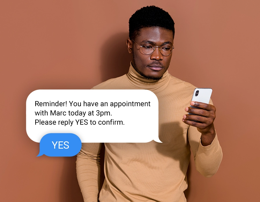 Man holding phone receiving reminder message for his appointment