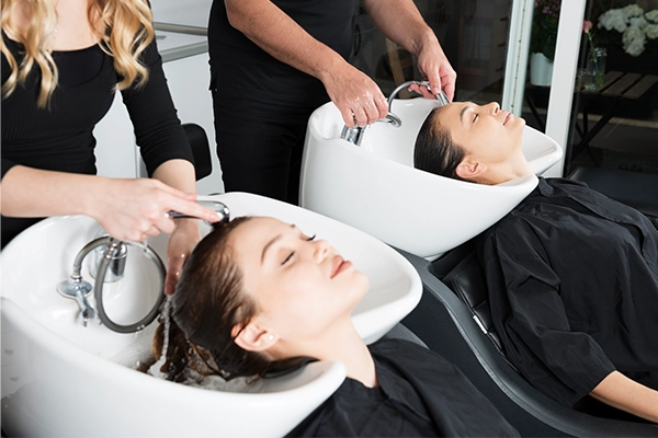 Two females getting their hair washed at the salon