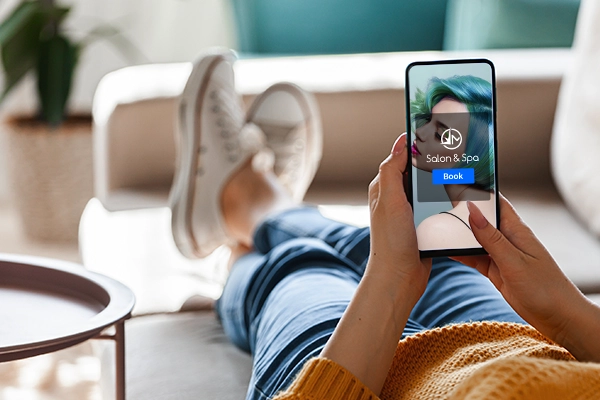 women at home booking an appointment on mobile phone